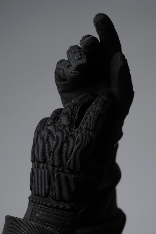Black tactical glove on a gray background