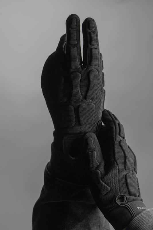 Black tactical gloves on a gray background